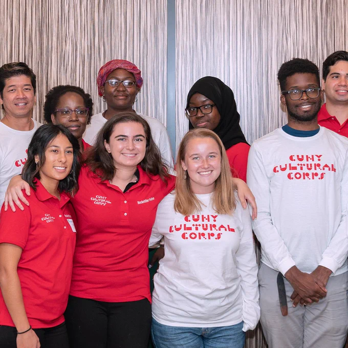 A group photo of Cultural Corps members wearing red and white Cultural Corps shirts and smiling for the camera 