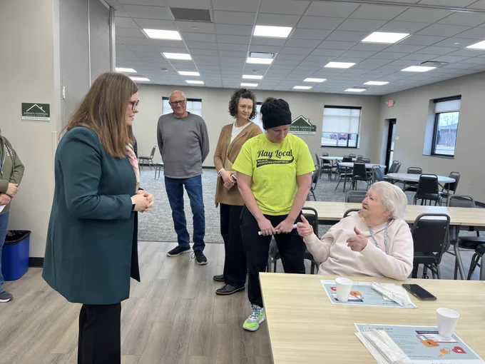 DOA Secretary Kathy Blumenfeld talks with a woman at the Waupun Community Center while Rachel Kaminski, recreation center program director; Laura Hoekstra, food pantry board member; and Joel Sterk, Waupun Food Pantry board president listen.