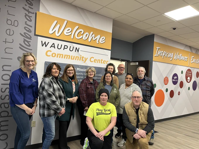 At the Waupun Community Center. Front row, kneeling: Rachel Kaminski, recreation center program director; BJ DeMaa, fire chief. Middle row: Terri Respalje, executive director of the Waupun Food Pantry and Community Table. Back row: Grace Bruins, REACH Waupun board president; Jayne Harmsen, executive director of Reach Waupun; DOA Secretary Kathy Blumenfeld; Kathy Schlieve, City of Waupun administrator; Laura Hoekstra, food pantry board member; and Joel Sterk, Waupun Food Pantry board president.
