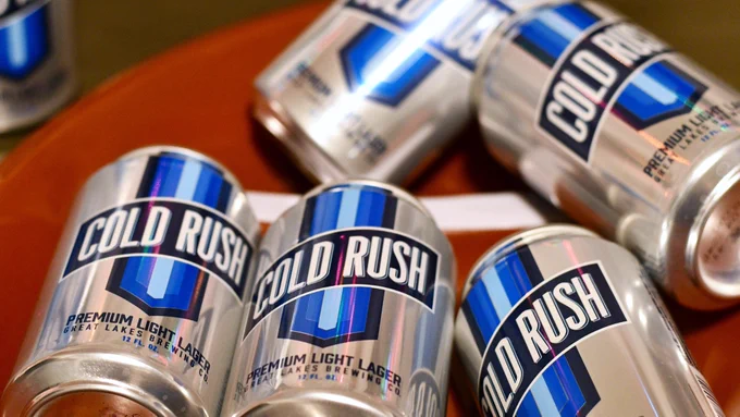 A football shaped tray of Cold Rush Premium Light Lager by Great Lakes Brewing Co. laid out at a superbowl watch party.