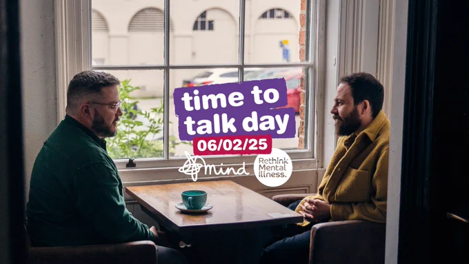 Col and Tom sit and chat over coffee in a local coffee shop, the Time to Talk Day logo is overlaid.