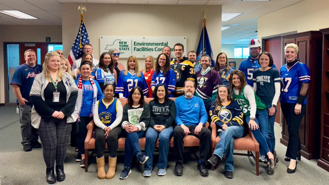 group photo of EFC employees wearing jerseys and sports apparel in the office reception area 