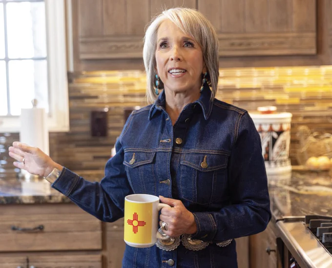 Gov. Michelle Lujan Grisham speaks in her kitchen holding a Zia flag coffee mug.