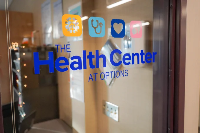The health center logo on the window at the health center