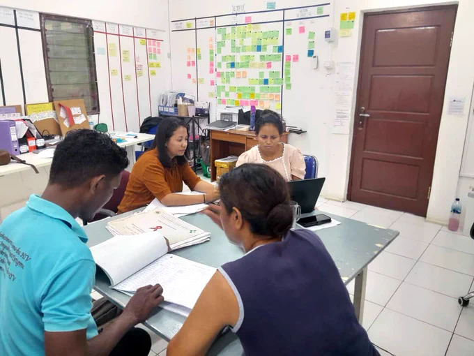 Atilo, Maria, Nurse Ima, and STEPT Project Manager Maia discussing the monthly collection of HIV/syphilis DUO test data from antenatal care patients at the Formosa Community Health Centre. 