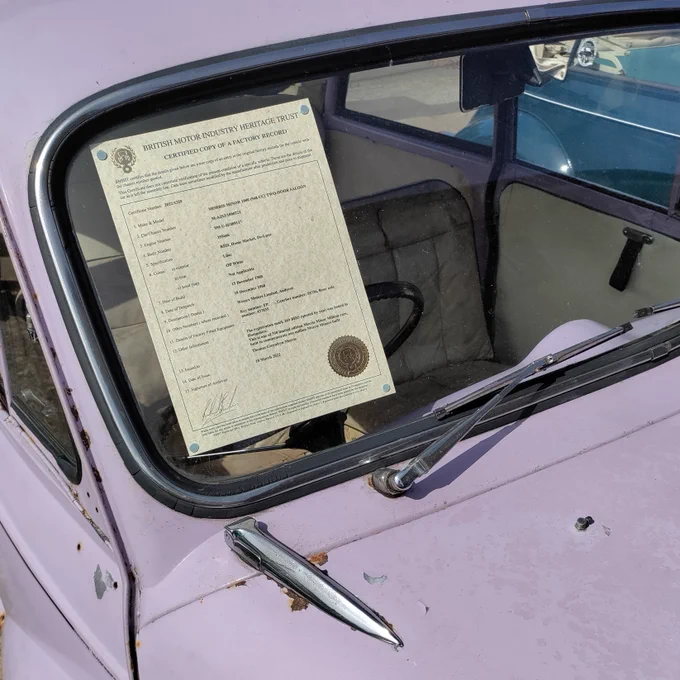 A BMIHT Heritage Certificate on display in the window of a Morris Minor Million