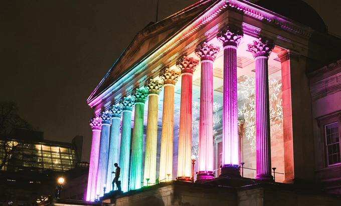 UCL’s Portico lit in rainbow colours at night. 