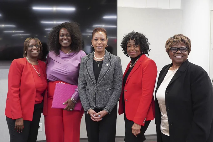 Speaker Adams posing for a group photo with four women