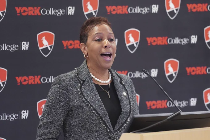 Speaker Adams speaking in front of a york college backdrop