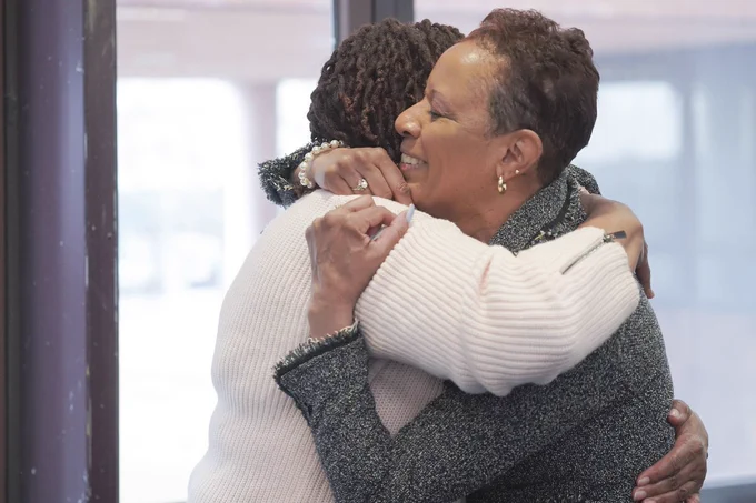 Speaker Adams smiling and hugging someone