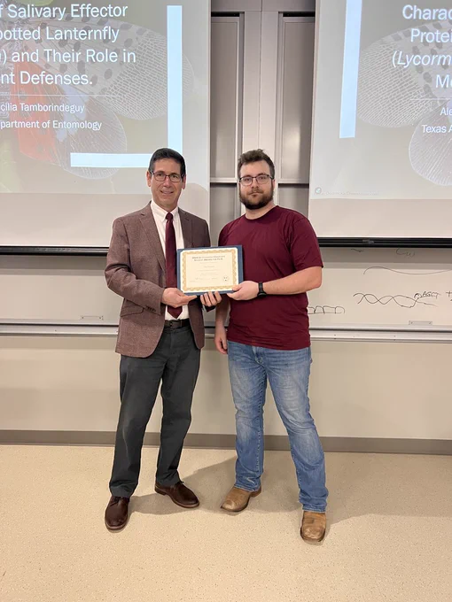 Phillip Kaufman, Ph.D., Department Head of Entomology and Professor stands next to Ph.D. candidate, John Grunseich for a photo presenting him with an award. 