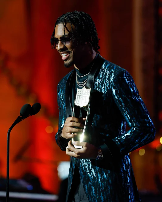Photo of Jayden Daniels on stage at NFL Honors accepting the award for Offensive Rookie of the Year.