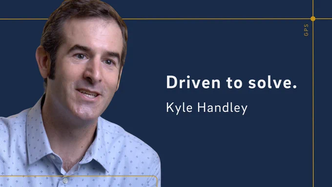 GPS professor Kyle Handley. Text reads, "Driven to solve. Kyle Handley"