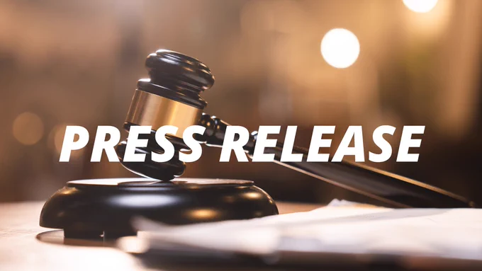 Brown gavel in a courtroom with the word Press Release in white, all-caps text.