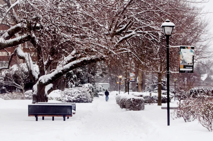 A student walking in the snow on campus