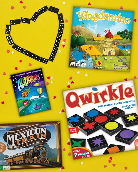 Yellow background with tiny red, white, & pink heart confetti with dominoes in a hart shape next to the box covers of Kingdomino, Aquarius, Mexican Train, and Quirkle