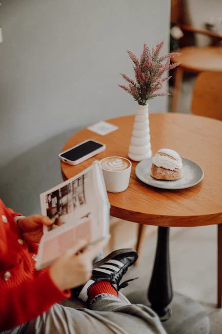 A person reading a magazine in a cozy Istanbul cafe with coffee and a semla.