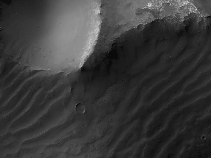 Image cutout shows a dark dune field adjacent to an old, eroded impact crater on Mars. (NASA/JPL-Caltech/University of Arizona)