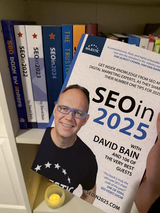 Hand holding the SEO in 2025 book by Majestic with David Bain