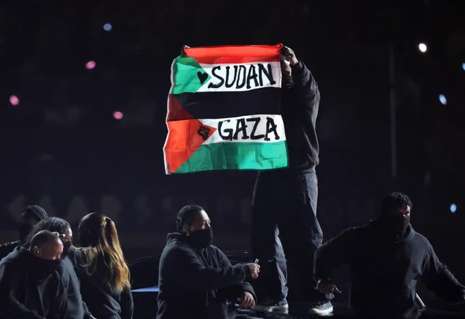 Protestor holding and Palestine and Sudan flags during the Super Bowl halftime show.