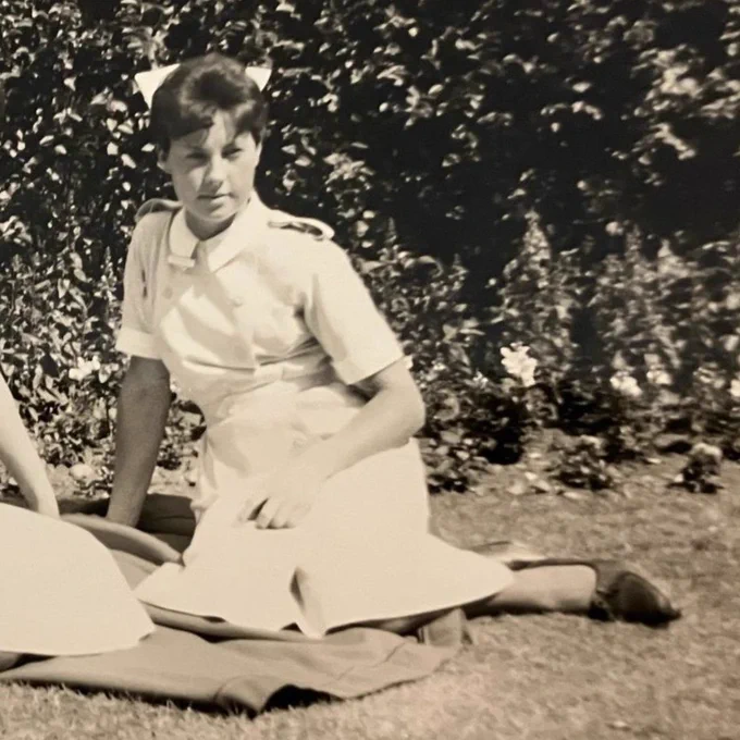 A photograph of Dianne when she was younger in her uniform, sat outside. 