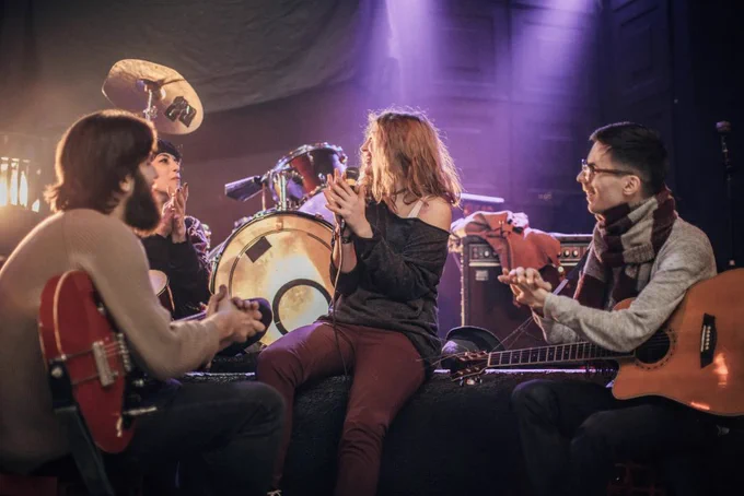 Imagen fotográfica de banda musical de jóvenes en escenario. 