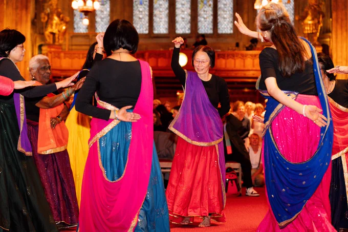 Akademi dance group stand in a circle as they dance.