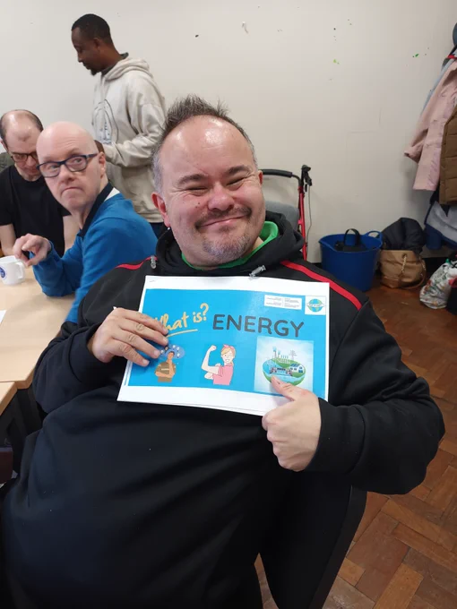 Individual holding up the "What is energy?" booklet and smiling.