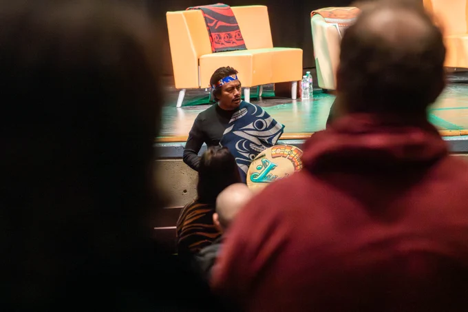 University of the Fraser Valley Indigenous Knowledge Keeper Qothyetel, John H. Williams, drumming at the stage of Mission Clarke Theatre