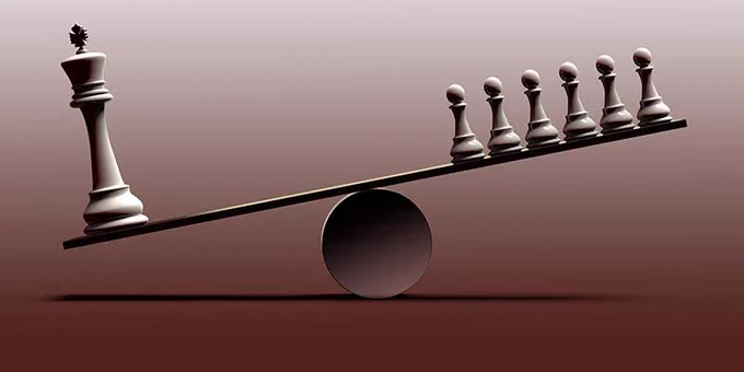 Chess pieces on a see saw