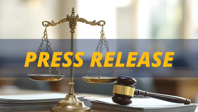 Scales of Justice, gavel, and documents on a courtroom table. Press Release is spelled out in all-caps, gold lettering.
