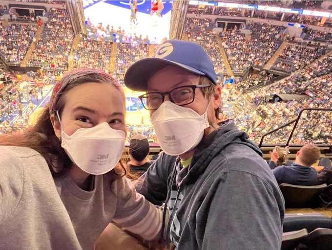 Sarah and her husband, both vaccinated and wearing 3M N95 respirators, love watching NBA games.