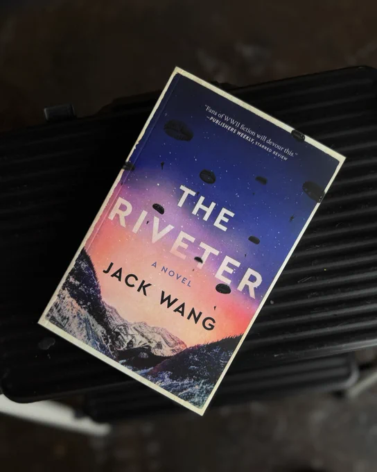 A photo of the book The Riveter on a black stool. The photo is taken from above.