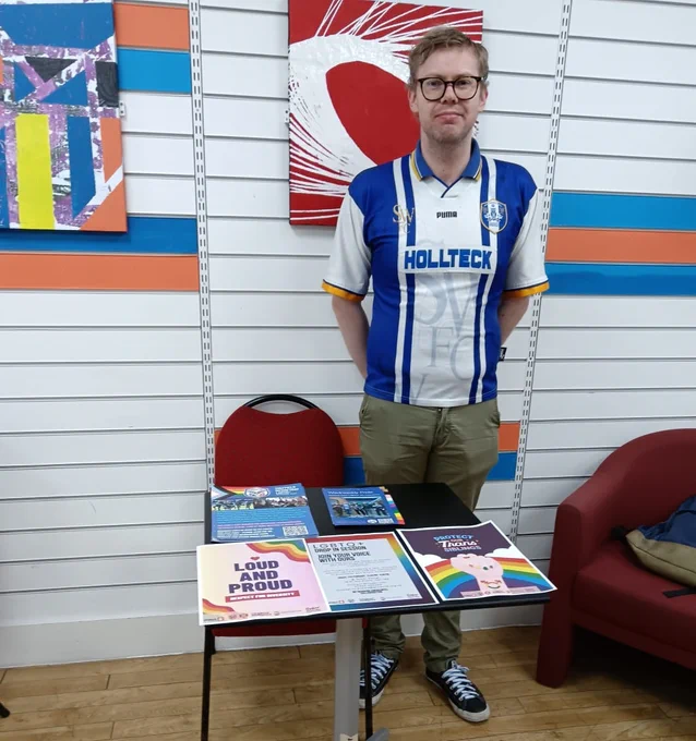 A photo of Rainbow Owls chair and founder Chris Ledger managing a stall at Project 6's recent LGBTQ  event.