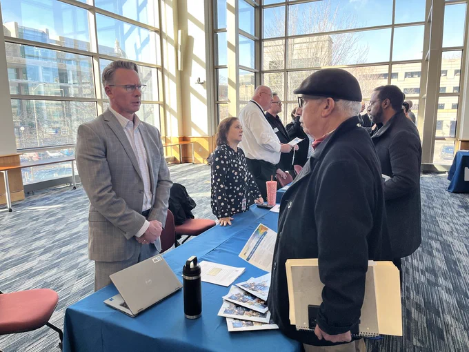 A man discusses procurement with a vendor at the MNIT IT Vendor Fair.