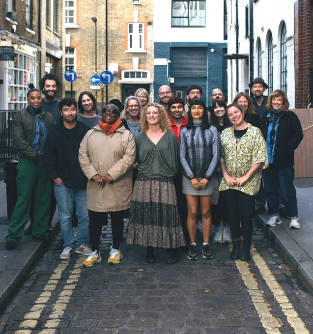 A group of network participants gather outside together on a street.