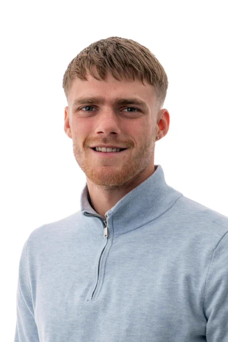 Image of Felix, an apprentice in the Property team at Network Rail, smiling, wearing a light blue zip-up top.