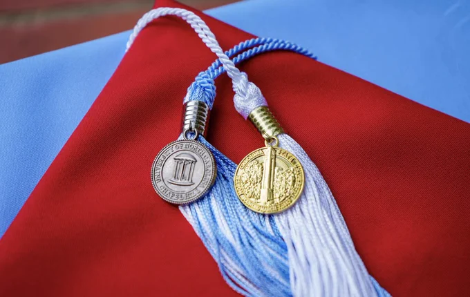 Two graduation caps, one for UNC and one for NC State