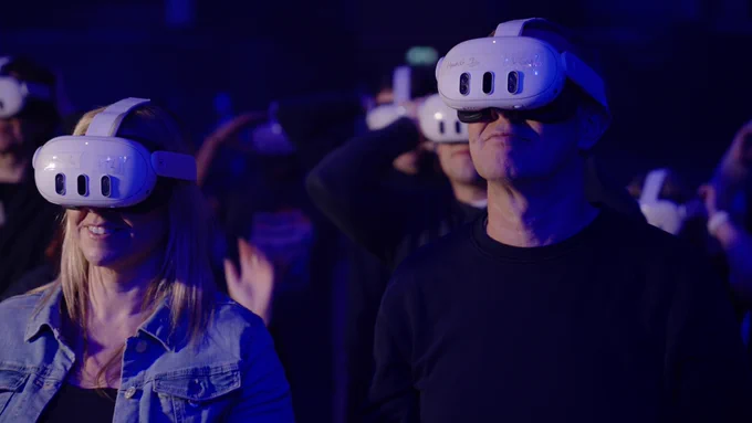 Two people at the front or a crowd wearing AR headsets in the Corn Exchange.