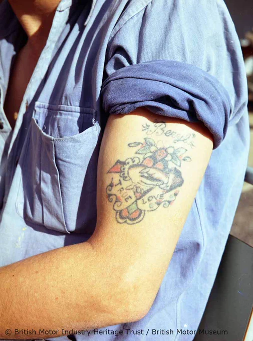 A colour photograph of a man's upper arm with his sleeve rolled up, showing a tattoo with the name "Beryl" and a man and woman's hands holding each other with the words "True Love" written beneath.  