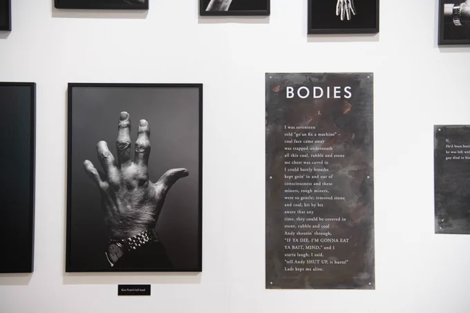 A tintype photograph of a left hand, the hand is missing part of the little and ring finger. To the right of the photograph is a piece on poetry entitled 'Bodies' on a black background with white text.