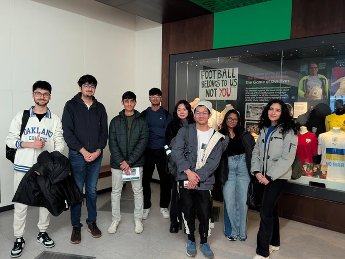 Students posing in front of a display at the museum