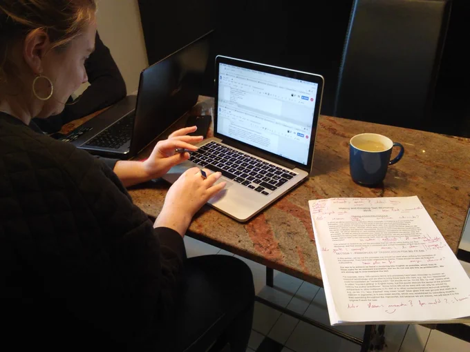 student working on laptop will well-annotated essay. 