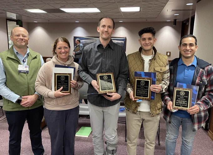 Bystanders and a hospital representative from MountainStar Healthcare’s Mountain View Hospital pose together as a group, smiling, with their recognition awards for saving a life.