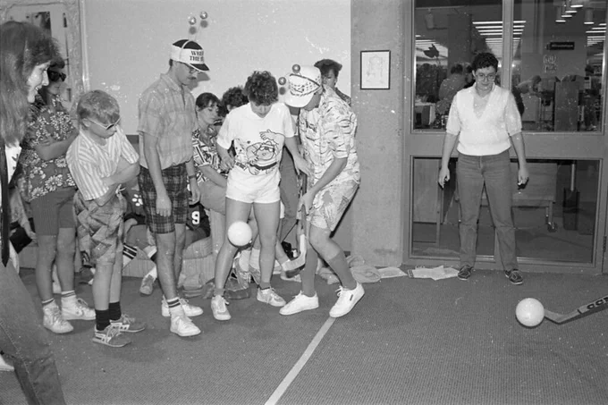 A black and white image of a group of people playing in a relay race.