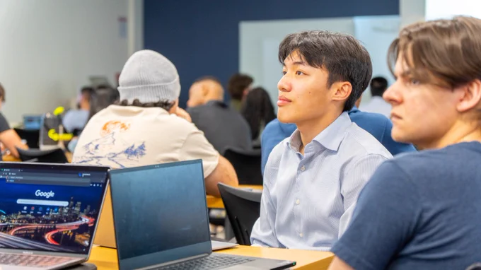 students at a table with laptops