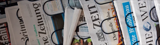 A collection of various newspapers including titles like The New York Times and USA Today, displayed with their front pages partially visible.