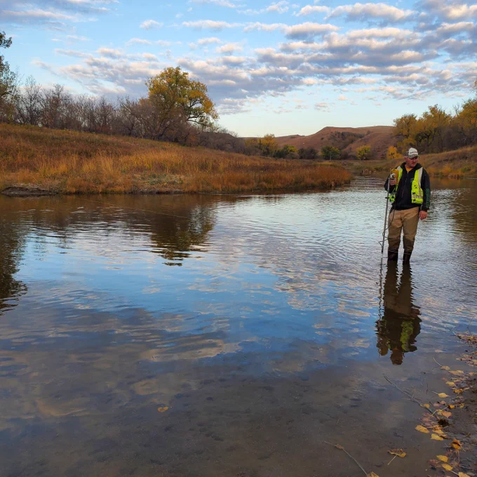 A USGS Hydrologist demonstrates how to make a low flow wading measurement using a flowtracker at USGS streamgage, Heart River at Stark Bridge near Judson, North Dakota.  