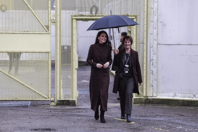 The Princes of Wales and a member of staff walking under an umbrella at HMP/YOI Styal.