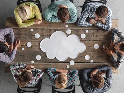 A group sitting around a table, sharing ideas